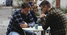 Two men praying on a cafe patio