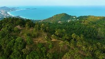 Mountain and cliff in the middle of the sea. Beautiful nature drone flying over green jungle mountain peaks. Aerial drone video of tropical paradise exotic island