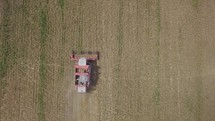 Aerial top view of Combine harvester working on wheat field
