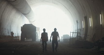 Workers walking inside a large tunnel construction project