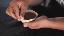 Man molding clay into a bowl