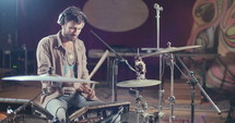 Drummer playing on electronic drum set in a recording studio