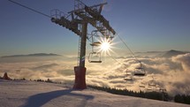 Sunny panorama in winter ski resort with empty chairlift and fresh snow on alpine slope in beautiful morning mountains
