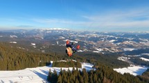 Paraglider fly above winter forest nature, Paragliding adrenaline adventure freedom
