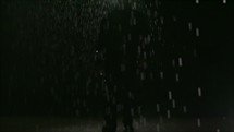 a man standing in the rain at night 
