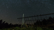 Time lapse dolly shot of a starry sky with milky way over a horse cart 