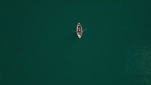 aerial view over a boat paddling on water 