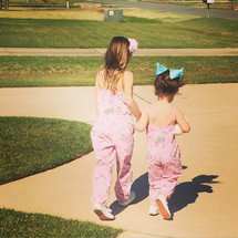 cousins in matching outfits walking holding hands 