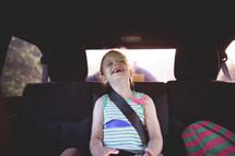 a girl laughing in the backseat 