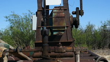 Close up detail of an oil well pump jack drawing crude from the ground