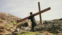 a man carrying a large cross