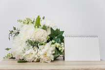 wedding bouquet and blank notepad 