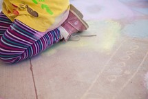 a child and sidewalk chalk 