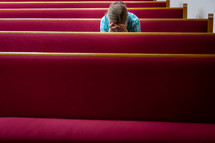 a crying woman sitting in church pews 