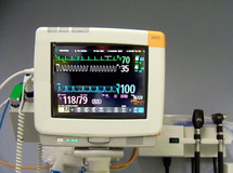 A Patient Monitor in a hospital emergency room showing a patient's blood pressure and vital statistics from their hospital bed. 