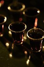 Communion cups with red wine on a translucent background.