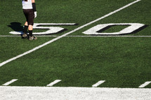Football player at the fifty yard line on a field