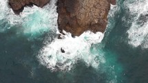 Aerial shot of waves crashing on the rocky coast line of Tung Lung Island in Hong Kong.