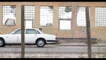 old warehouse building and passing car 