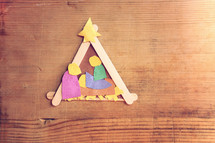 a simple children's rendition of the nativity made from popsicle sticks and construction paper