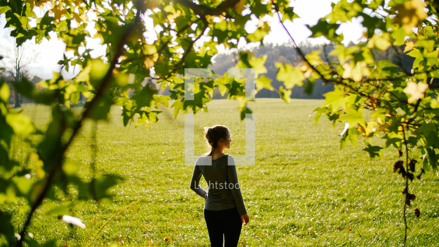 woman standing in a field of cut grass