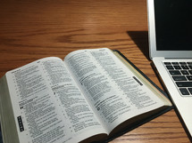 laptop computer and Bible on a desk 