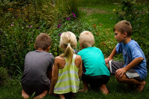 kids watching creatures in a flower garden 