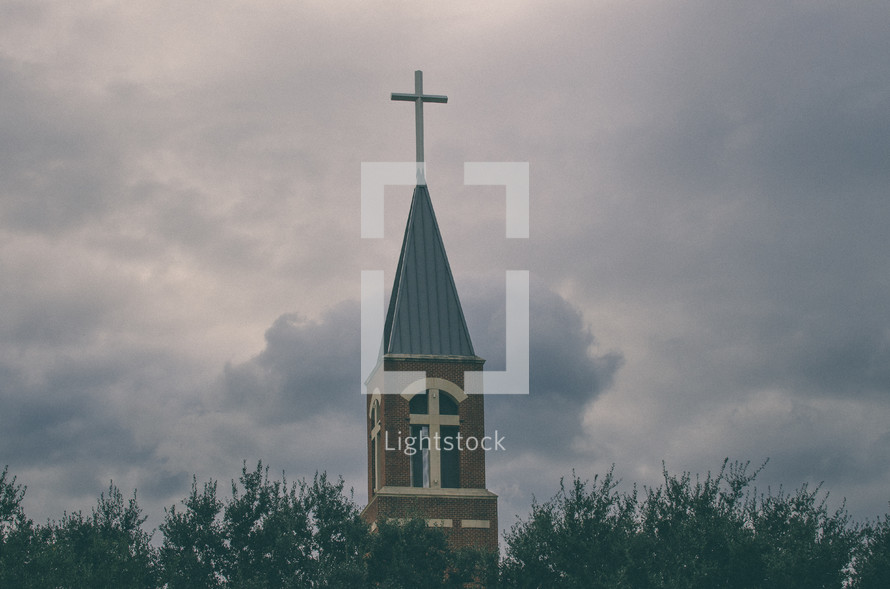 Church belfry and steeple against stormy clouds.