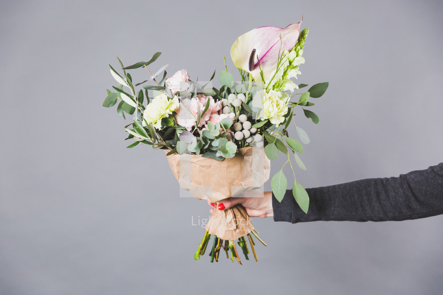 a woman holding out a bouquet of flowers 