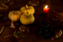 a candle with fall pumpkins