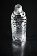 A refreshing bottle of water on seamless black