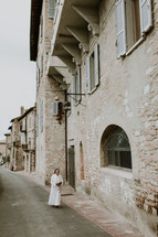 a nun walking on a narrow street 