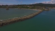 aerial view over a rocky shore and jetty 