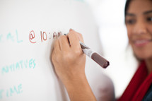 woman writing on a dry erase board 