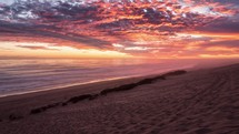 Beautiful sunrise with bloody sky and red clouds over ocean coast beach in summer nature Time lapse

