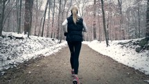 a woman jogging in the snow 