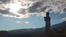 a man standing on a mountaintop praying 