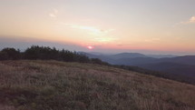 Sunset over meadow in mountains landscape Aerial view

