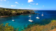 Beautiful scene of boats and a calm turquoise snorkeling location in Maui, Hawaii.