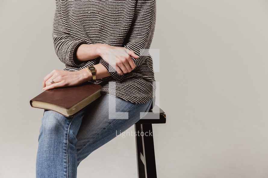 woman sitting on a stool with a Bible in her lap