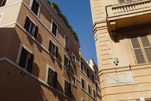 windows on the sides of buildings lining the narrow streets of Rome 