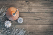 silver and orange pumpkins on an aged wood background