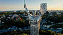 Kyiv, Ukraine - September, 2022: aerial view of Motherland Monument. Drone footage with sun flares. Monumental statue in the capital. One of most important sights of city
