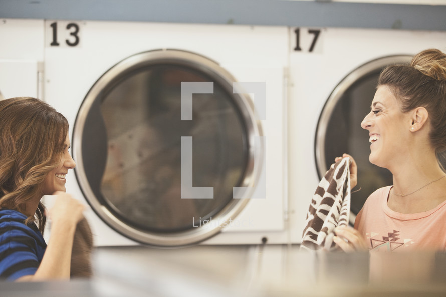 women doing laundry at a laundry mat