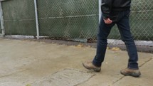 man walking on a sidewalk on a rainy day 