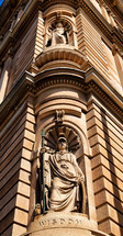 statue of wisdom carved into the corner of a building 