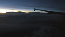 wing of a plane flying above the clouds 
