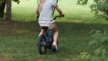 Young kids ride their bikes through the backyard