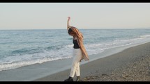 Girl dance on the beach near the ocean
