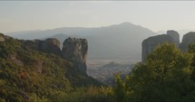 The incredible Greek monasteries on the rocks with the town below. Meteora, Greece during a summers evening. 